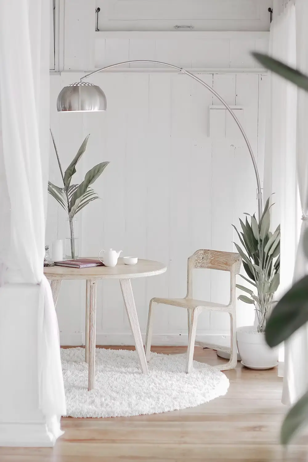 Framed artwork beside a dark vase with greenery